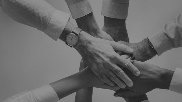 Hands joined together in the middle of a circle Hands joined together in the middle of a circle